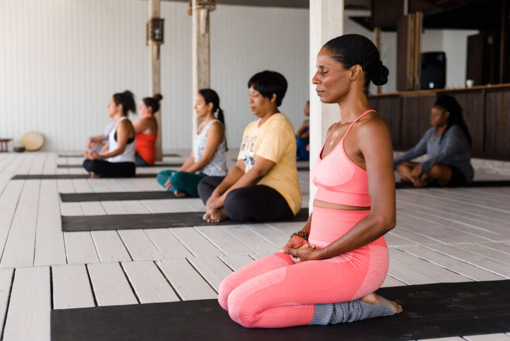 A group of women meditating on yoga mats, illustrating a key concept of Kaizen. 